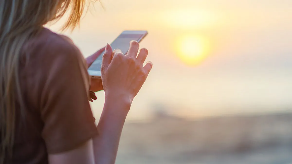 Women using app on the beach on holiday