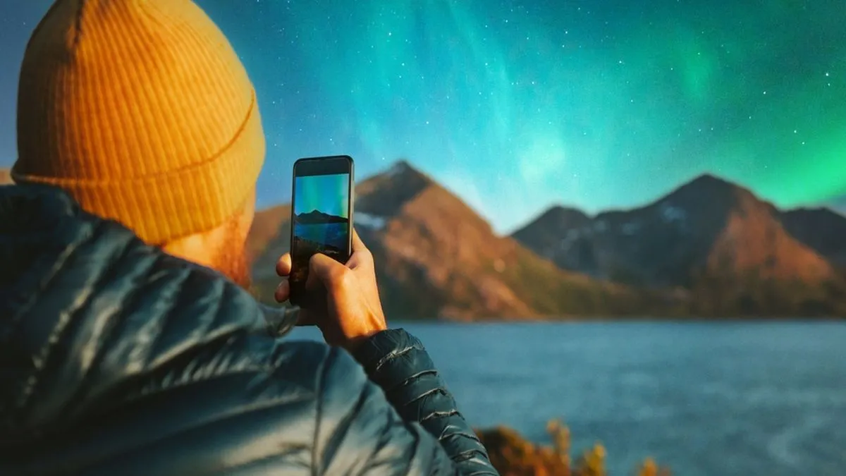 Person using their phone to photograph the Northern Lights