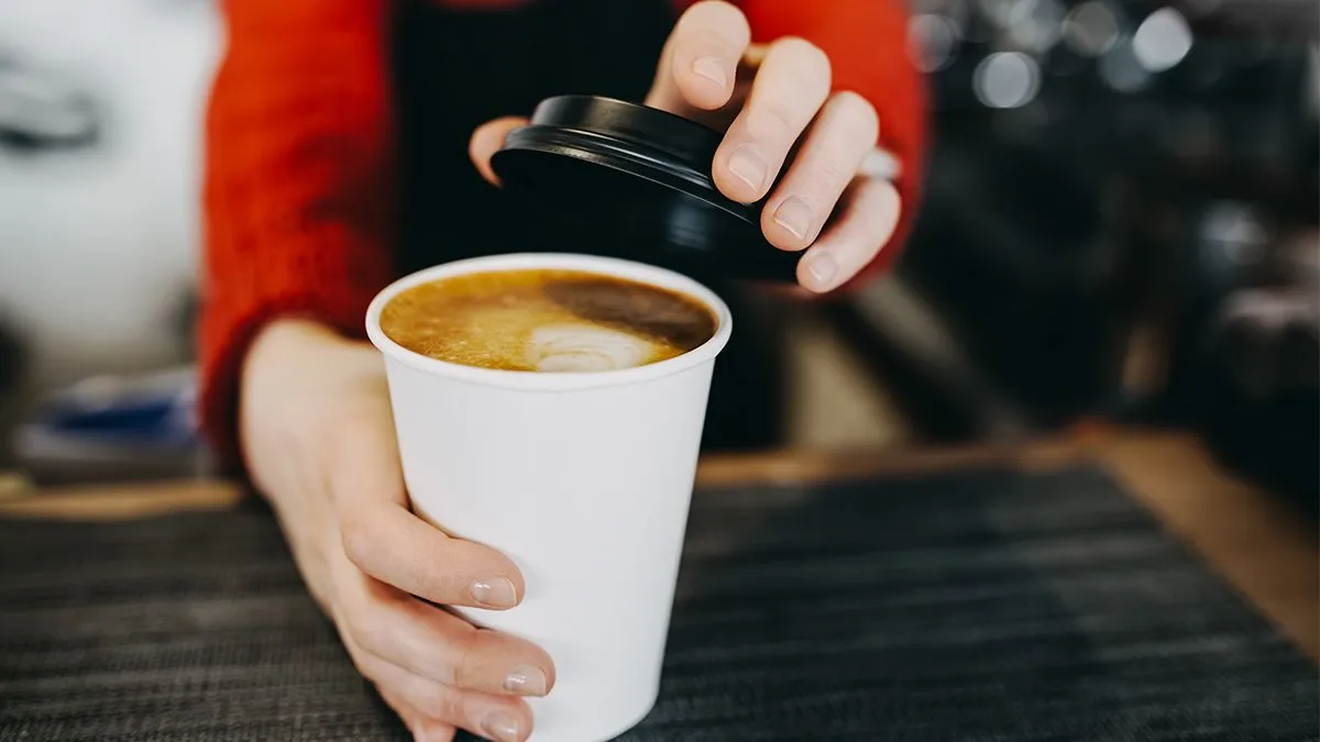 Barista handing over coffee cup