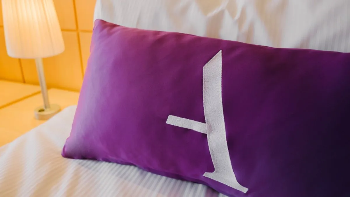 Close-up of an Ambassador Cruise line pillow on a bed