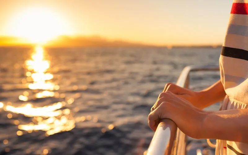 Woman looking out at the sea from a cruise ship